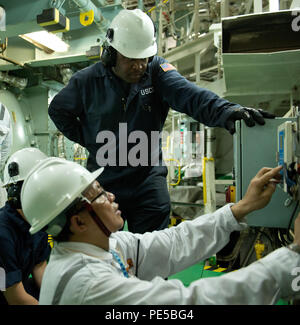 Petty Officer 1st Class Edgar Douglas, ein Marine science Techniker, und seine shipmate Beobachten ein Ingenieur Test Engine Room Equipment, die während einer Inspektion an Bord eines bulk carrier Schiff im Hafen von Houston, Dienstag, Sept. 29, 2015. Die Küstenwache führt Überprüfungen im Rahmen der Hafenstaatkontrolle gemäß der Marine Safety Manual Sicherheit des Lebens auf See zu gewährleisten. (U.S. Coast Guard Foto von Petty Officer 3. Klasse Jennifer A. Nease) Stockfoto