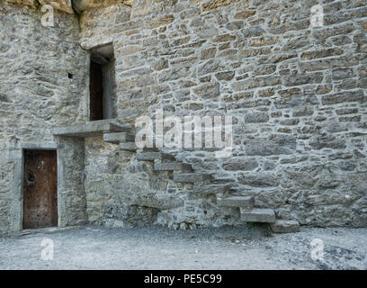 Altes Steinhaus mit einem hölzernen Tür und einem externen steinerne Treppe in die obere Etage zu einer offenen Tür Stockfoto