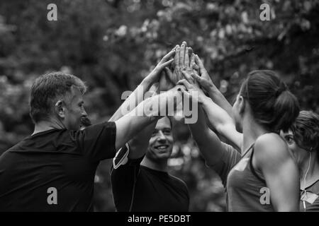 Gruppe von gesunden Läufer, fünf auf einander beim Erfolg feiern nach dem Training. Stockfoto