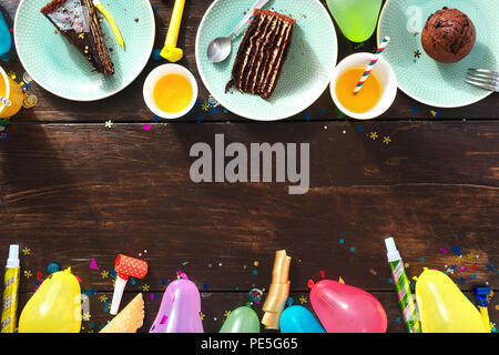 Ansicht von oben Kinder geburtstag Tabelle Konzept. Rahmen der Schokolade Kuchen und Dekoration Party auf braunem Holz- hintergrund Flach Stockfoto