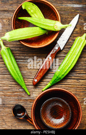 Ernte raw Green Organic okra auf einer hölzernen Hintergrund. Vegetarismus Stockfoto