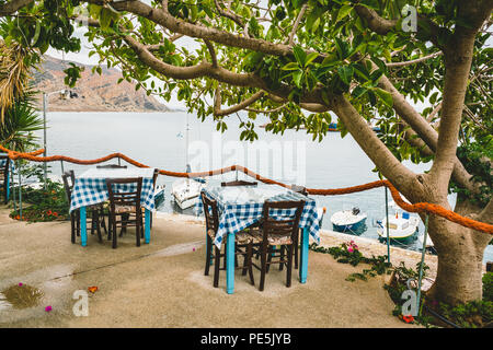 Griechenland Kreta. Restaurant mit serviert Tabelle in Küste der Insel mit atemberaubendem Meerblick, erstaunliche und eine unglaubliche Aussicht auf das Wasser. Traditionelle g Stockfoto