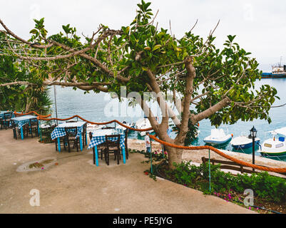 Griechenland Kreta. Restaurant mit serviert Tabelle in Küste der Insel mit atemberaubendem Meerblick, erstaunliche und eine unglaubliche Aussicht auf das Wasser. Traditionelle g Stockfoto