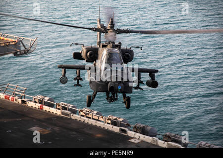 ARABIAN GULF (Sept. 28, 2015) Eine AH-64 Apache mit 185 der US-Armee Theater Aviation Brigade bereitet sich auf Land an Bord der Amphibisches Schiff USS Essex (LHD2). Diese Soldaten praktiziert Landung und Abflug von den Essex, um sich mit den Flugbetrieb an Bord eines Schiffes vertraut zu machen. 15 Marine Expeditionary Unit, an Bord der Schiffe der Essex amphibischen bereit, Gruppe, bereitgestellt ist die regionale Sicherheit in den USA 5 Flotte Bereich der Betrieb aufrecht zu erhalten. (U.S. Marine Corps Foto von Cpl. Elize McKelvey/Freigegeben) Stockfoto