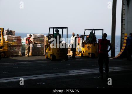 ARABIAN GULF (Sept. 29, 2015) US-Marines mit dem 15 Marine Expeditionary Unit und Matrosen bewegen Paletten während einer Auffüllung auf See an Bord der Amphibisches Schiff USS Essex (LHD2). Marinesoldaten und Matrosen arbeiteten zusammen, um über das Essen, Ausrüstung zu sortieren, und E-Mails, die Sie während der RAS empfangen. 15 Marine Expeditionary Unit, an Bord der Schiffe der Essex amphibischen bereit, Gruppe, bereitgestellt ist die regionale Sicherheit in den USA 5 Flotte Bereich der Betrieb aufrecht zu erhalten. (U.S. Marine Corps Foto von Cpl. Anna Albrecht/Freigegeben) Stockfoto