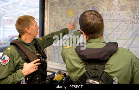 Lt.Cmdr. Jeremy Loeb und Oberstleutnant Zach Gross, sowohl MH-65 Hubschrauberpiloten, Ort der Ausbildung bei Air Station Houston, Sept. 29, 2015 diskutieren. Nacht Operations Training bereitet die Flugzeugbesatzungen Für die gewaltige Aufgabe, eine Rettung mit sehr wenig Licht und schlechter Sicht. (U.S. Coast Guard Foto von Petty Officer 3. Klasse Dustin R. Williams). Stockfoto