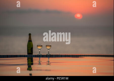 Champagner durch einen Infinity-Pool, wie die Sonne Stockfoto