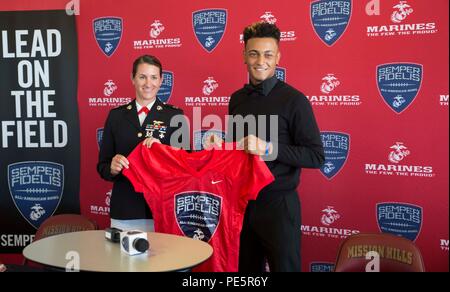 Kapitän Catherine Zeigler, der Executive Officer der einziehenden Station San Diego, präsentiert ein Semper Fidelis All-American Bowl game Jersey zu High School Troy Warner am Mission Hills High School in San Marcos, Calif., Sept. 30, 2015. Warner wurde ausgewählt für die Teilnahme an der SFAAB, geplant für 1. Jan. in Carson, Calif Warner spielt cornerback für die Mission Hills Grizzlies varsity Football Team auch weiterhin seine athletischen Fähigkeiten Showcase im nächsten Jahr an der Brigham Young University. Stockfoto