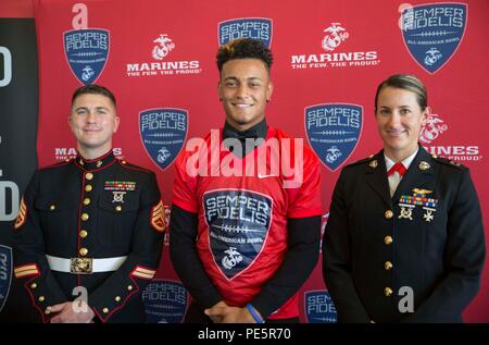 Staff Sgt. Jared Buell, ein Personalvermittler für die Rekrutierung der Unterstation Oceanside (links), und Kapitän Catherine Zeigler, der Executive Officer für Recruiting Station San Diego (rechts), an der Semper Fidelis All-American Bowl game Jersey Präsentation für High School Troy Warner (Mitte) an der Mission Hills High School in San Marcos, Calif., Sept. 30, 2015. Warner wurde ausgewählt für die Teilnahme an der SFAAB, geplant für 1. Jan. in Carson, Calif Warner spielt cornerback für die Mission Hills Grizzlies varsity Football Team auch weiterhin seine athletischen Fähigkeiten Showcase im nächsten Jahr an der Brigham Young zu Stockfoto