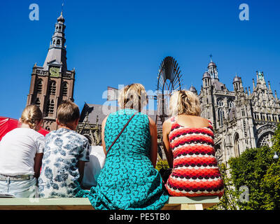 Leute sitzen auf Bänken und genießen den Blick auf die Kathedrale St. John's in 's-Hertogenbosch, Niederlande, während der Boulevard Street Theater Stockfoto