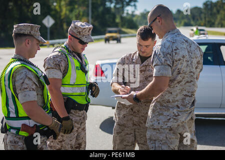 Marine Wachen beschreiben Sie die Situation für die Beseitigung von Explosivstoffen Marines während dringende Antwort 2015 auf die Marine Corps Base Camp Lejeune Okt. 7. Dringende Antwort ist eine jährliche, umfassende Übung entworfen, um zu prüfen, und Basis Rettungsdienst Zug reagieren zu einer großen Krise Incident, welche simuliert ein Fahrzeug - getragene Improvised Explosive Device und enthalten die Zusammenarbeit der Rettungsdienste auf, um mit der Installation zu schließen Feuer und Polizeidienststellen, Emergency Operations Center und Naval Hospital Camp Lejeune. Stockfoto