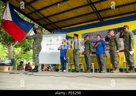 Philippinische service Mitglieder und US Marine Corps Oberst Charles Western, Stabschef, 3. Marine Expeditionary Brigade, grüßen die Flagge Philippinen während der Nationalhymne für einen Bandausschnitt Zeremonie für die humanitäre civic Hilfe Projekt in Concepcion Volksschule in Palawan, Philippinen, während amphibische Landung Übung 2015 (15) PHIBLEX, Okt. 8. 15 PHIBLEX ist eine jährliche bilaterale Ausbildung Übung mit der Streitkräfte der Philippinen durchgeführt, um die Interoperabilität zu stärken und die Zusammenarbeit in einem breiten Spektrum von militärischen Operationen von der Katastrophe Stockfoto