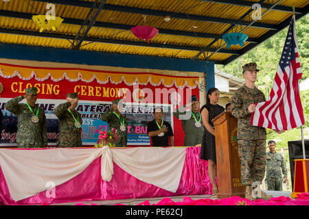 Philippinische service Mitglieder und US Marine Corps Oberst Charles Western, Stabschef, 3. Marine Expeditionary Brigade, begrüssen die amerikanische Flagge während der Nationalhymne für einen Bandausschnitt Zeremonie für die humanitäre civic Hilfe Projekt bei Binduyan Volksschule in Palawan, Philippinen, während amphibische Landung Übung 2015 (15) PHIBLEX, Okt. 8. 15 PHIBLEX ist eine jährliche bilaterale Ausbildung Übung mit der Streitkräfte der Philippinen durchgeführt, um die Interoperabilität zu stärken und die Zusammenarbeit in einem breiten Spektrum von militärischen Operationen von Disaster reli Stockfoto