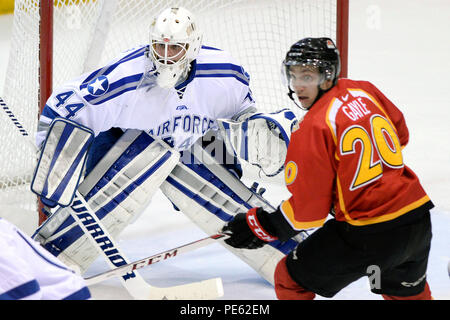 Goalie Billy Christopoulos, ein Neuling, hat ein Auge auf den Puck als Calgary Danny Gayle sieht für einen Pass vor dem Falcon Ziel als Air Force der Universität von Calgary Dinos in einer Ausstellung College Hockey matchup bei der US Air Force Academy Cadet Ice Arena in Colorado Springs, Colo Okt. 5, 2015. Die Falken besiegt Calgary 5-0. Air Force öffnet seine reguläre Saison gegen Nr. 5 geordnete Denver Pioniere am Cadet Ice Arena Okt. 9, 2015. (Air Force Foto/Mike Kaplan) (freigegeben) Stockfoto