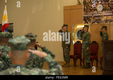 Us Marine Corps Brig. Gen. Paul J. Kennedy, 3. Marine Expeditionary Brigade, Kommandierender General (links), philippinische Marine Corps Generalmajor Romeo T. Tanalgo, die Streitkräfte der Philippinen (AFP), (Mitte) und Colonel Nathaniel Casem, philippinische Marine Readiness Force (PRF), PRF, (rechts), grüßen die Philippinische Flagge als die Philippinische. Nationalhymne während der amphibische Landung PHIBLEX Übung 2015 (15) Abschlussfeier, Okt. 09 gespielt. 15 PHIBLEX ist eine jährliche bilaterale Übung mit der AFP-durchgeführt, um die Interoperabilität zu stärken und Arbeitsbeziehungen acro Stockfoto