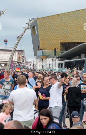 Blackpool, Großbritannien. 12. August 2018 - Menschenmassen versammeln die Blackpool Airshow zu sehen, einschließlich einer Leistung durch die RAF Red Arrows. Die roten Pfeile flogen vor dem Hintergrund des aufkommenden Sturm und durchgeführt für eine Menge von zig Tausend entlang der Promenade in Blackpool. Credit: Benjamin Wareing/Alamy leben Nachrichten Stockfoto