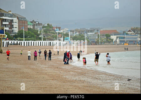Weymouth Beach. 12. Aug 2018. UK Wetter. Nach einem nassen Nachmittag am späten Abend Sonne scheint auf auf Leute spielen und schwimmen am Strand von Weymouth in Dorchester. Credit: Robert Timoney/Alamy leben Nachrichten Stockfoto