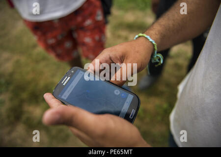 In der Nähe von Sturlic, in der Nähe von Sturlic, Bosnien und Herzegowina. 11 Aug, 2018. Einer der Flüchtlinge gesehen, in der Richtung auf einem Smartphone. Eine Gruppe von drei Flüchtlinge aus dem Lager in Velika Kladusa, um zu versuchen, die Grenze zu überqueren. In der lokalen Slang es das Spiel aufgerufen wird. Wenn Sie Italien ohne nicht durch die Polizei, die sie das Spiel gewinnen wird gefangen wird. Wenn Sie von der Kroatischen Polizei erwischt, werden Sie zurück in Bosnien geschoben werden und Sie verlieren. Credit: Attila Husejnow/SOPA Images/ZUMA Draht/Alamy leben Nachrichten Stockfoto
