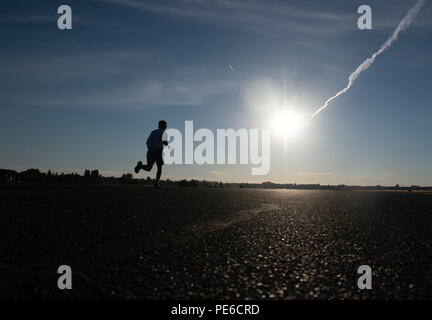 Berlin, Deutschland. 13 Aug, 2018. Ein Mann joggt auf der Landebahn des ehemaligen Flughafen Tempelhof in den frühen Morgen. Credit: Paul Zinken/dpa/Alamy leben Nachrichten Stockfoto