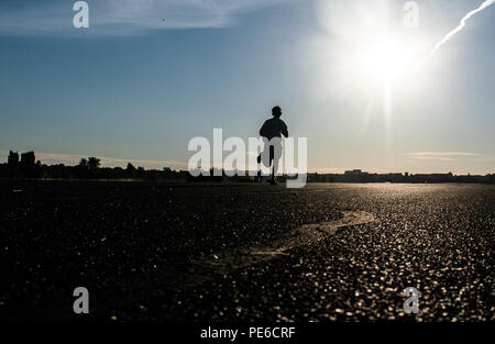 Berlin, Deutschland. 13 Aug, 2018. Ein Mann joggt auf der Landebahn des ehemaligen Flughafen Tempelhof in den frühen Morgen. Credit: Paul Zinken/dpa/Alamy leben Nachrichten Stockfoto