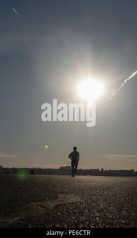 Berlin, Deutschland. 13 Aug, 2018. Ein Mann joggt auf der Landebahn des ehemaligen Flughafen Tempelhof in den frühen Morgen. Credit: Paul Zinken/dpa/Alamy leben Nachrichten Stockfoto