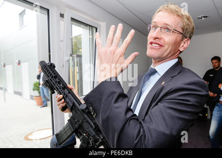 Eutin, Deutschland. 13 Aug, 2018. Daniel Günther der Christlich Demokratischen Union (CDU), Ministerpräsident von Schleswig-Holstein, hält eine Polizei Gewehr in der Hand. Guenther wird Schleswig-Holstein Institutionen auf seiner Sommerreise Besuch bis zum 16. August. Credit: Frank Molter/dpa/Alamy leben Nachrichten Stockfoto