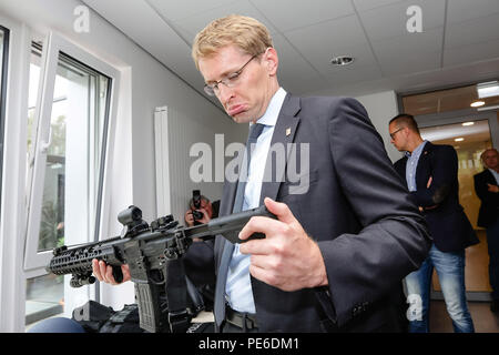 Eutin, Deutschland. 13 Aug, 2018. Daniel Günther der Christlich Demokratischen Union (CDU), Ministerpräsident von Schleswig-Holstein, prüft die Polizei Gewehr. Guenther wird Schleswig-Holstein Institutionen auf seiner Sommerreise Besuch bis zum 16. August. Credit: Frank Molter/dpa/Alamy leben Nachrichten Stockfoto