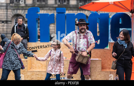 Edinburgh, Schottland, Großbritannien. Am 13. August 2018. Eine Street Performer unterhält Touristen im Regen und Nieselregen auf der Royal Mile in der Altstadt von Edinburgh. Credit: Ben Collins/Alamy leben Nachrichten Stockfoto