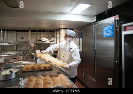 ARABIAN GULF (Okt. 2010) 12, 2015) Kulinarische Specialist 2. Klasse Clara Hart-positionen Brot für in der Pantry an Bord Wasp - Klasse amphibisches Schiff USS Essex (LHD2). Essex ist das Flaggschiff der Essex amphibische Gruppe und bereit, mit der begonnen 15 Marine Expeditionary Unit (15 MEU), ist zur Unterstützung der Maritime Security Operations und Theater Sicherheit Zusammenarbeit in den USA 5 Flotte Bereich der Operationen eingesetzt. (U.S. Marine Foto von Mass Communication Specialist 2. Klasse Molly A. Sonnier / freigegeben) Stockfoto