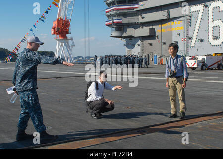 151013-N-YD 641-074 Yokosuka, Japan (Okt. 2010) 13, 2015) Leutnant Phillip Chitty, Assistant Public Affairs Officer an Bord der US-Navy ist nur Vorwärts - bereitgestellt Flugzeugträger USS Ronald Reagan (CVN 76), erklärt Flight Deck Operationen in den japanischen Medien während einer Tour des Schiffes. Ronald Reagan und seine eingeschifft Air Wing, Carrier Air Wing (Cvw) 5, eine Bekämpfung bereit, Kraft, schützt und verteidigt die kollektive maritime Interessen seiner Verbündeten und Partnern in der Indo-Asia-Pazifik-Region. (U.S. Marine Foto von Mass Communication Specialist Seaman Matthew Riggs / freigegeben) Stockfoto