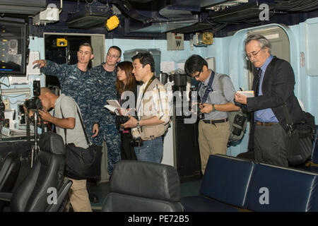 151013-N-YD 641-132 Yokosuka, Japan (Okt. 2010) 13, 2015) Air Traffic Controller 2. Klasse Michael Schwarm, von Myrtle Point, Erz, erklärt Flugbetrieb in Air Operations Center an Bord der US-Navy ist nur Vorwärts - bereitgestellt Flugzeugträger USS Ronald Reagan (CVN 76). Ronald Reagan und seine eingeschifft Air Wing, Carrier Air Wing (Cvw) 5, eine Bekämpfung bereit, Kraft, schützt und verteidigt die kollektive maritime Interessen seiner Verbündeten und Partnern in der Indo-Asia-Pazifik-Region. (U.S. Marine Foto von Mass Communication Specialist Seaman Matthew Riggs / freigegeben) Stockfoto