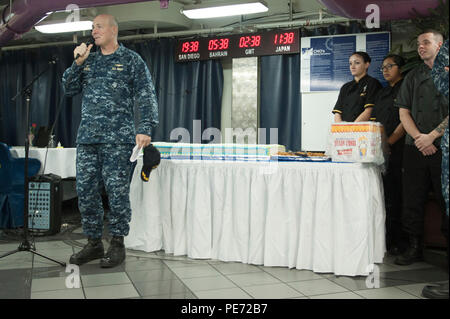 151013-N-ZZ 999-261 Yokosuka, Japan (Okt. 2010) 13, 2015) Kapitän Christopher Schraube, kommandierender Offizier der US-Marine vorwärts - bereitgestellt Flugzeugträger USS Ronald Reagan (CVN 76), schneidet einen Kuchen zusammen mit Mitgliedern der Crew nach einer Zeremonie zur Feier des 240. Geburtstag der Marine. Ronald Reagan und seine eingeschifft Air Wing, Carrier Air Wing (Cvw) 5, eine Bekämpfung bereit, Kraft, schützt und verteidigt die kollektive maritime Interessen seiner Verbündeten und Partnern in der Indo-Asia-Pazifik-Region. (U.S. Marine Foto von Mass Communication Specialist Seaman MacAdam Weissman/Freigegeben) Stockfoto