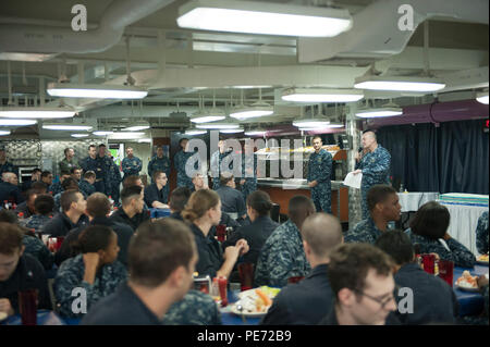 151013-N-ZZ 999-275 Yokosuka, Japan (Okt. 2010) 13, 2015) Kapitän Christopher Schraube, kommandierender Offizier der US-Marine vorwärts - bereitgestellt Flugzeugträger USS Ronald Reagan (CVN 76), Adressen Mitglieder der Besatzung, die auf das Chaos Decks während einer Zeremonie in der Feier des 240. Geburtstag der Marine. Ronald Reagan und seine eingeschifft Air Wing, Carrier Air Wing (Cvw) 5, eine Bekämpfung bereit, Kraft, schützt und verteidigt die kollektive maritime Interessen seiner Verbündeten und Partnern in der Indo-Asia-Pazifik-Region. (U.S. Marine Foto von Mass Communication Specialist Seaman MacAdam Weissman/Freigegeben) Stockfoto