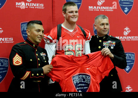 Logan Bathke einen High School senior bei Orange Lutheran High School in Orange, Calif., wirft mit Maj. James Dollard, Marine Corps Recruiting Orange County kommandierenden Offizier, und die Mitarbeiter der Sgt. Noe Santana, ein Marine Corps Recruiting Orange County Kundenwerbung Recruiter, nach präsentiert wird ein Semper Fidelis All-American Bowl game Jersey 9 Oktober, 2015. Bathke wurde gewählt in der SFAAB, geplant für 14.01.3 in Carson, Calif Bathke spielt Offensive teilzunehmen für Varsity Football Team der Orange Lutherischen's Lancer anzugehen und wird auch weiterhin seine athletischen Fähigkeiten Showcase im nächsten Jahr an der Universität. Stockfoto