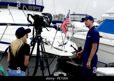 Hannah Mullins, ein Reporter der ABC 10 News San Diego, Interviews Petty Officer 3. Klasse eben Smith, ein Marine science Techniker an der Coast Guard Sektor San Diego Incident Management Division, über die Entdeckung eines Verletzten sea lion Während surge Umwelt Patrouillen der Küstenwache im Hyatt Regency Mission Bay Marina in San Diego durchgeführt am 16. Oktober 2015. Smith war der Erste, der das verletzte Tier- und Aufruf zur Unterstützung vor Ort. (U.S. Coast Guard Foto von Petty Officer 3. Klasse Joel Guzman) Stockfoto