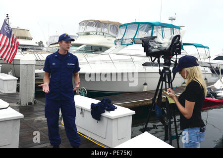 Hannah Mullins, ein Reporter der ABC 10 News San Diego, Interviews Petty Officer 3. Klasse eben Smith, ein Marine science Techniker an der Coast Guard Sektor San Diego Incident Management Division, über die Entdeckung eines Verletzten sea lion Während surge Umwelt Patrouillen der Küstenwache im Hyatt Regency Mission Bay Marina in San Diego durchgeführt am 16. Oktober 2015. Smith war der Erste, der das verletzte Tier- und Aufruf zur Unterstützung vor Ort. (U.S. Coast Guard Foto von Petty Officer 3. Klasse Joel Guzman) Stockfoto