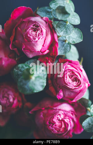 Makrofotografie von dunkel rosa Rosen Blumenstrauß über Blau. Soft Focus, Ansicht von oben, close-up Komposition. Stockfoto