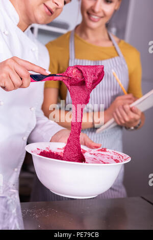 Koch tragen weiße Jacke mischen rosa Mousse zum Kochen Dessert Stockfoto