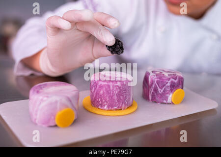 Baker tragen weiße Handschuhe halten wenig Mulberry in Ihrer Hand Stockfoto