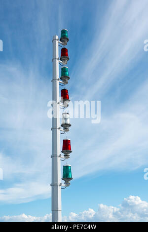 Grün und Rot maritime signal leuchten auf eine weiße Metall Spalte gegen einen sonnigen blauen Himmel. Stockfoto