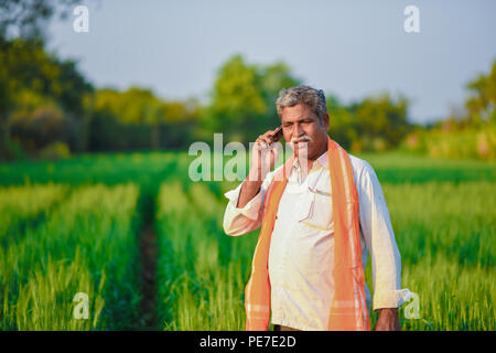 Inder in einem Feld am Telefon sprechen Stockfoto