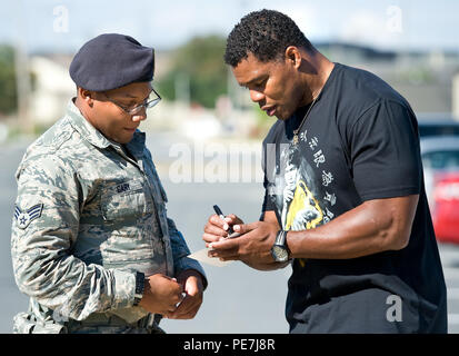 Ehemalige NFL zurück laufen und 1982 Heisman Trophy Sieger Herschel Walker, rechts, Autogramme ein Foto für Senior Airman Vernon, Gary, 512Th Security Forces Squadron Response Force leader, Links, Oktober 13, 2015, auf Dover Air Force Base, Del bei jedem Stopp auf seiner Basis Tour, Walker Autogrammen und beantwortet Persönliche und sportbezogene Fragen von Team Dover Mitglieder. (U.S. Air Force Foto/Roland Balik) Stockfoto