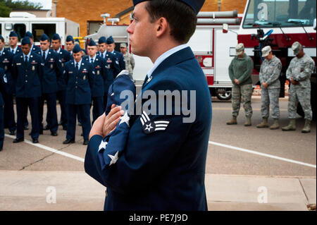 Cannon Feuerwehrmänner auf der 27 Special Operations Tiefbau Geschwader zugewiesen, erwarten die Anhebung der Fahne zu Hälfte - die Angestellten während einer Zeremonie an die gefallene Feuerwehrmänner gewidmet, der 4. Oktober 2015, an der Kanone Air Force Base, NM. Die Zeremonie wurde in der Befolgung der Glocken in ganz Amerika, ein Tag zu würdigen, Kolleginnen und Feuerwehrleute, die ihr Leben in den Dienst anderer gab gewidmet. (U.S. Air Force Foto/Tech. Sgt. Manuel J. Martinez) Stockfoto