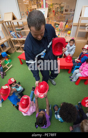 Belgischen Feuerwehrmann Guillaume Cauchie, mit Obersten Hauptquartier der Alliierten Mächte Europa Feuerwehr Hände Helme für Kinder mit Kind Entwicklung Mitte der Woche, während der Brandschutz in Form, Belgien, Okt. 13, 2015. (U.S. Armee Foto von visuellen Informationen Spezialist Pierre-Etienne Courtejoie/Freigegeben) Stockfoto