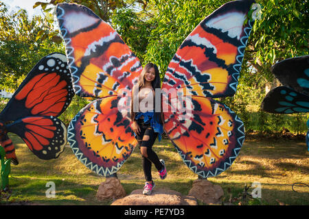 Junge Frau reisen in den Hidden Village Chiang Mai, Landschaft outdoor Jurassic Park mit riesigen Skulpturen Dinosaurier und andere Tiere Jurassic Welt Stockfoto