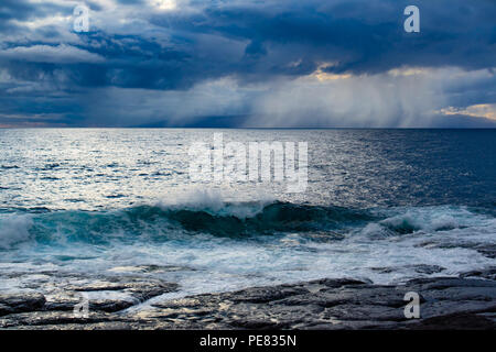 Meereslandschaft mit felsigen Ufer, atlantischen Ozean Wasser, dramatische Wolken mit Regen auf Teneriffa. Stockfoto