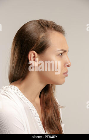 Wütende Frau auf Kamera. Aggressive Business woman stehen auf Grau studio Hintergrund isoliert. Weibliche Profil Portrait. Menschliche Gefühle, Mimik Konzept. Stockfoto