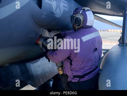 Aviation Boatswain’s Mate (Fuel) steckte während einer Composite Training Unit Exercise (COMPTUEX) am 23. Oktober 2015 einen Treibstoffschlauch in eine AV-8B Harrier auf dem Flugdeck des amphibischen Angriffsschiffs USS Boxer (LHD 4). Die Übung, an der Boxer, USS New Orleans (LPD 18), USS Harpers Ferry (LSD 49) und die 13th Marine Expeditionary Unit beteiligt sind, integriert Schiffe und Marines, um die Einsatzbereitschaft, die Koordination des Flugdecks, die Luftbetankungsverfahren und die Kampfbereitschaft für amphibische Angriffe und Expeditionsoperationen zu verbessern. Stockfoto