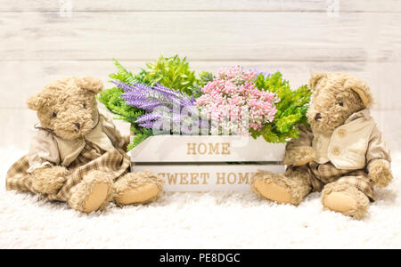 Blumen in einer Holzkiste und niedlichen Bären. Blumen in einem weißen Holzkasten, Plüsch vintage trägt. Romantisches Geschenk, Hintergrund für Herzlichen Glückwunsch! Stockfoto