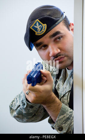 Staff Sgt. Christopher Walker, 436Th Security Forces Squadron Response Force leader, späht Um einen Schaltschrank Wand während eines simulierten Active shooter Szene Okt.20, 2015, in Gebäude 639 auf Dover Air Force Base, Del Walker, zusammen mit recht Beamte von Polizei, Dover Dover, Del; die Delaware State Polizei, Armee 3, Camden, Del, und 436Th SFS Personal, initiierte eine Schleife der ersten und zweiten Etage der Gebäude- und Lagerbereichen. (U.S. Air Force Foto/Roland Balik) Stockfoto